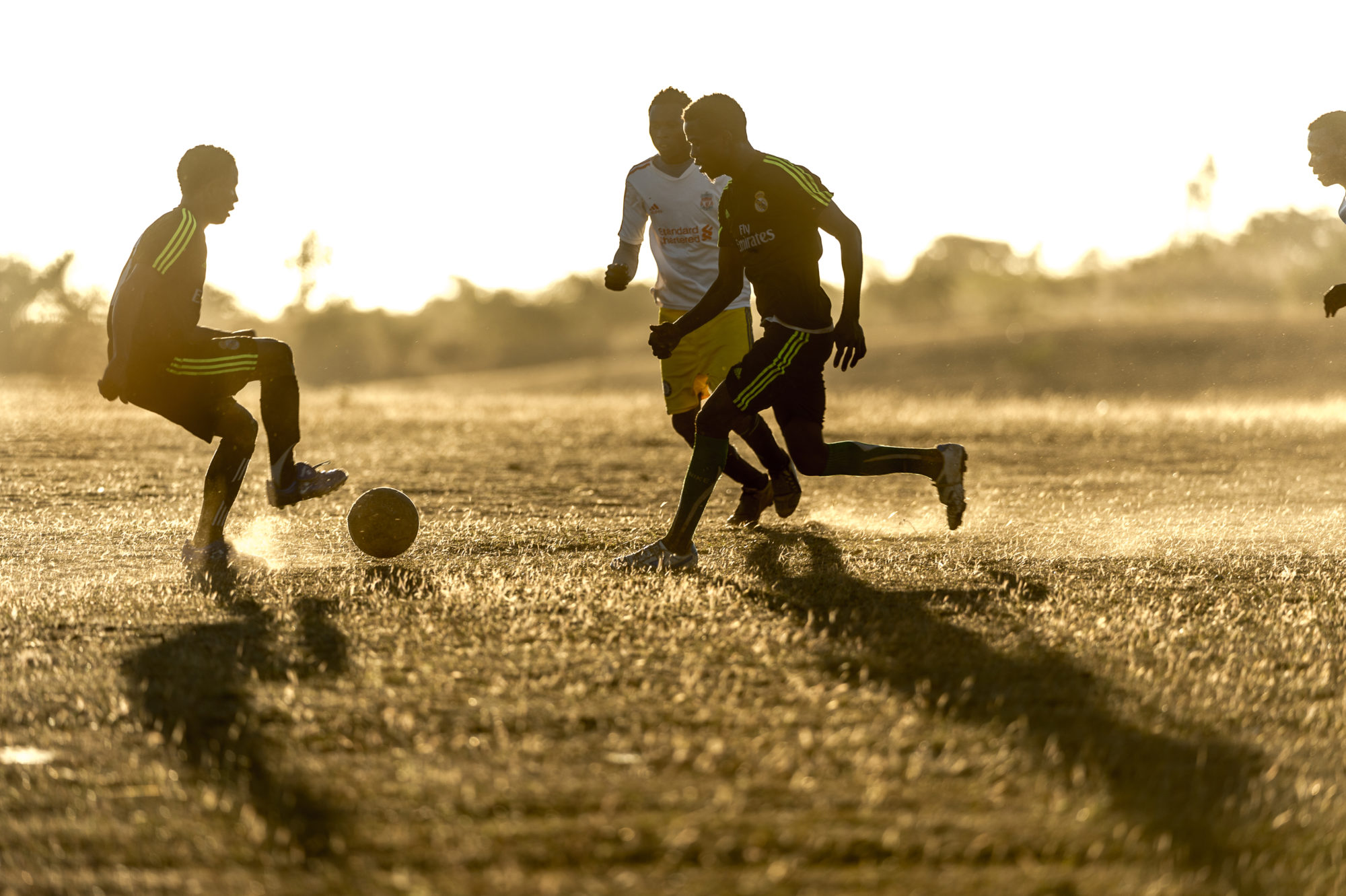 Foto di ragazzi giocano a calcio al tramonto