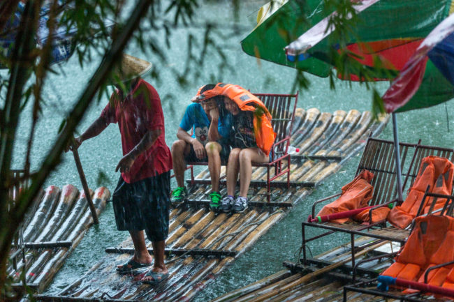 Zattere di turisti a Yangshuo sotto un acquazzone