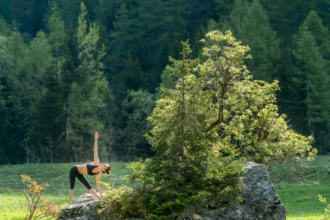 un'atleta pratica yoga in un bosco