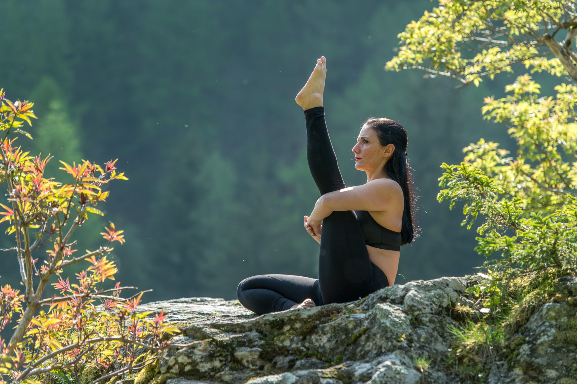 Foto di un’atleta pratica yoga in un bosco