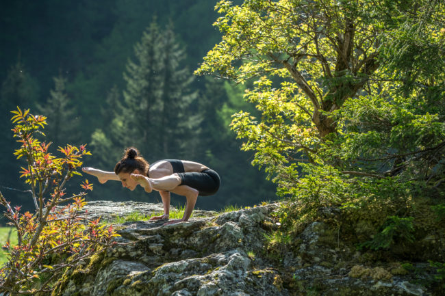 un'atleta pratica yoga in un bosco