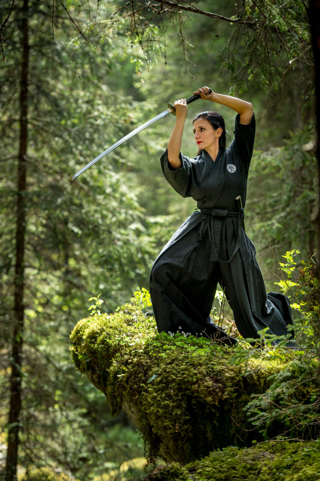donna pratica Yoga con la katana in mezzo alla natura