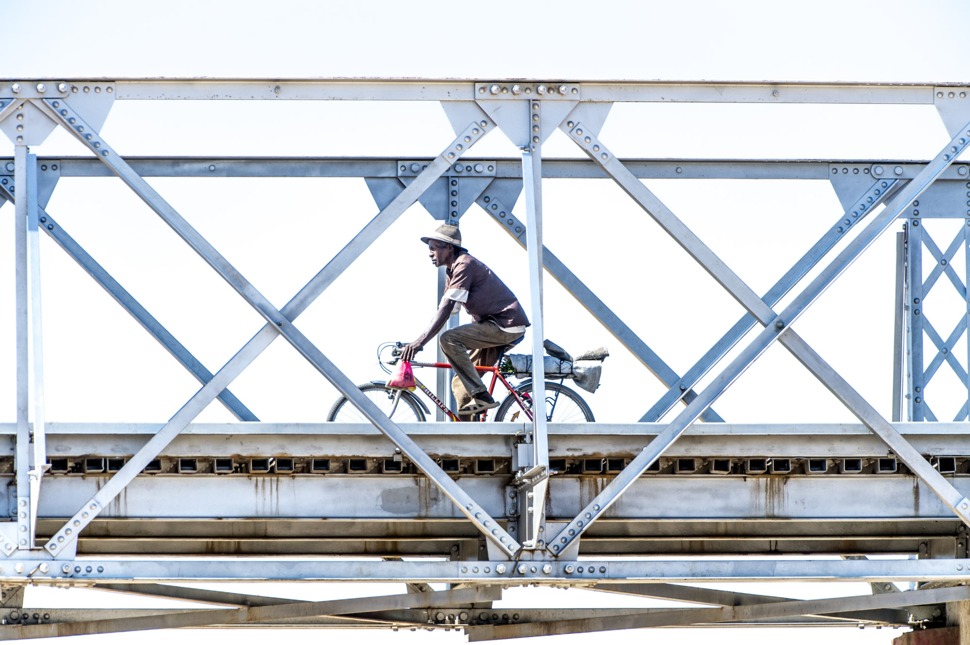 Foto di un uomo percorre un ponte in bicicletta