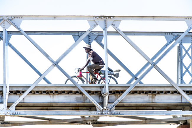un uomo percorre un ponte in bicicletta