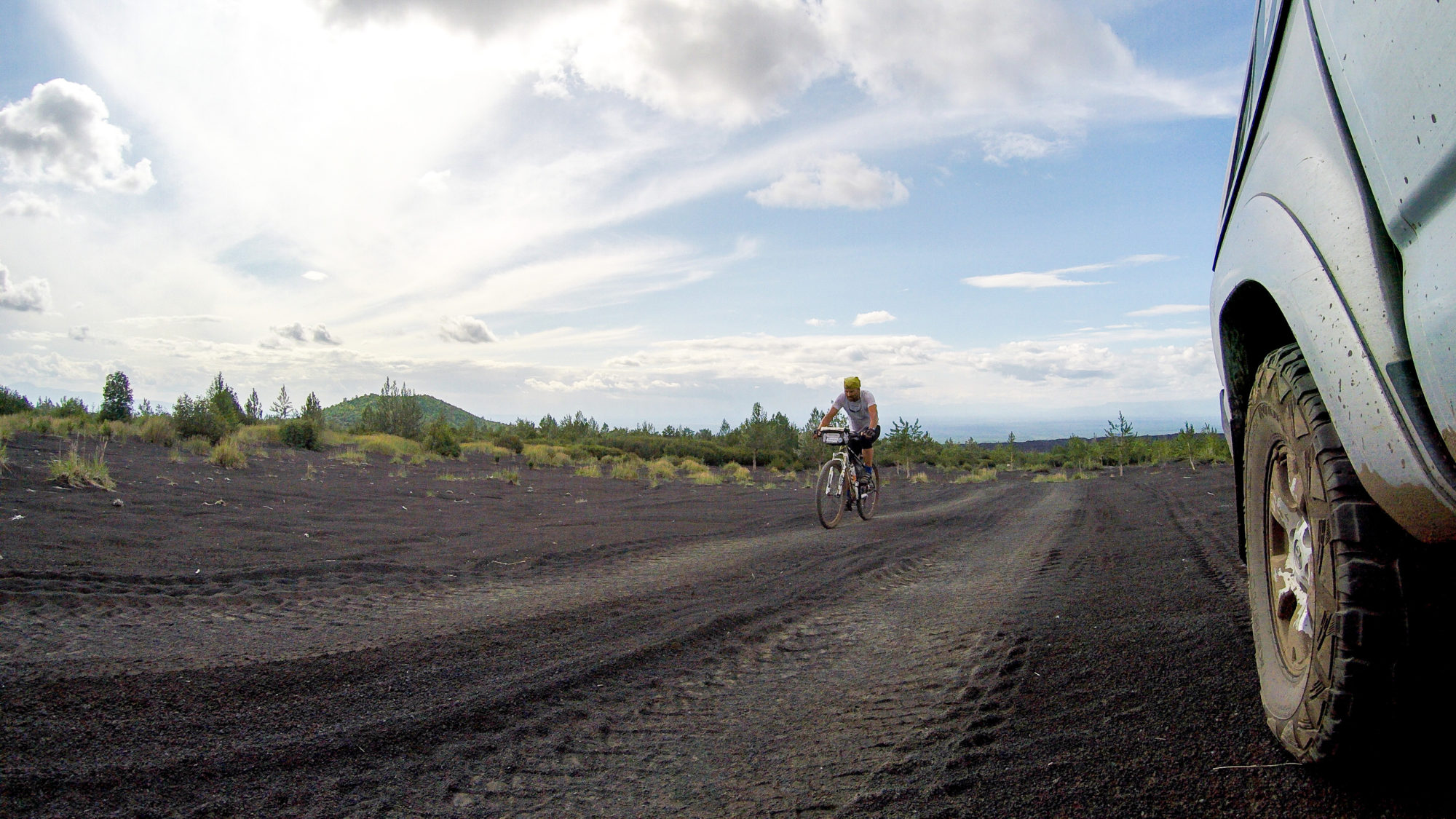 Foto di Aldo Mazzocchi pedala per raggiungere la base del vulcano Tolbachick