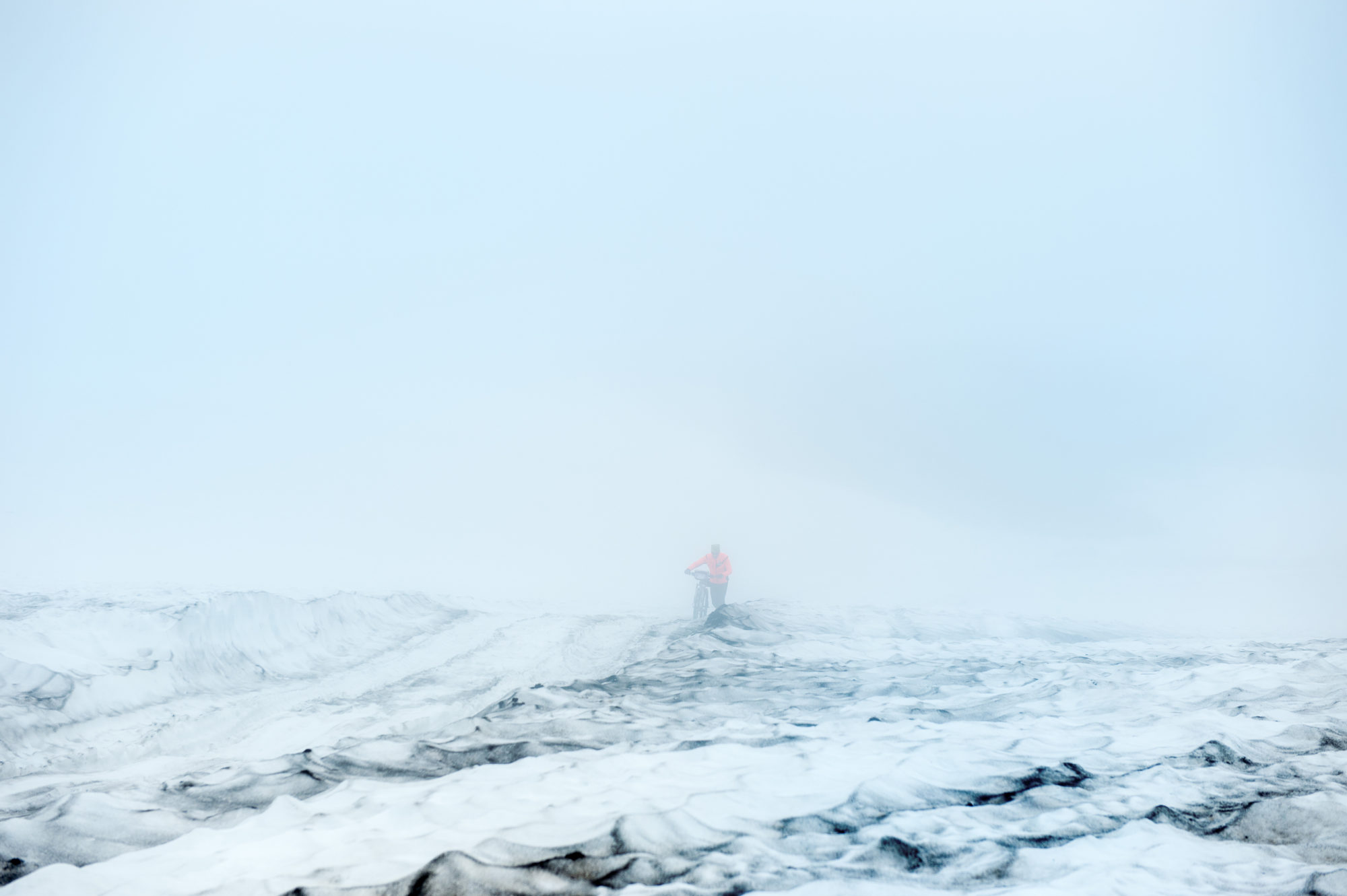 Foto di aldo mazzocchi è costretto a spingere la bicicletta sulla troppa neve che ricopre la strada che porta al campo base verso il vulcano gorely