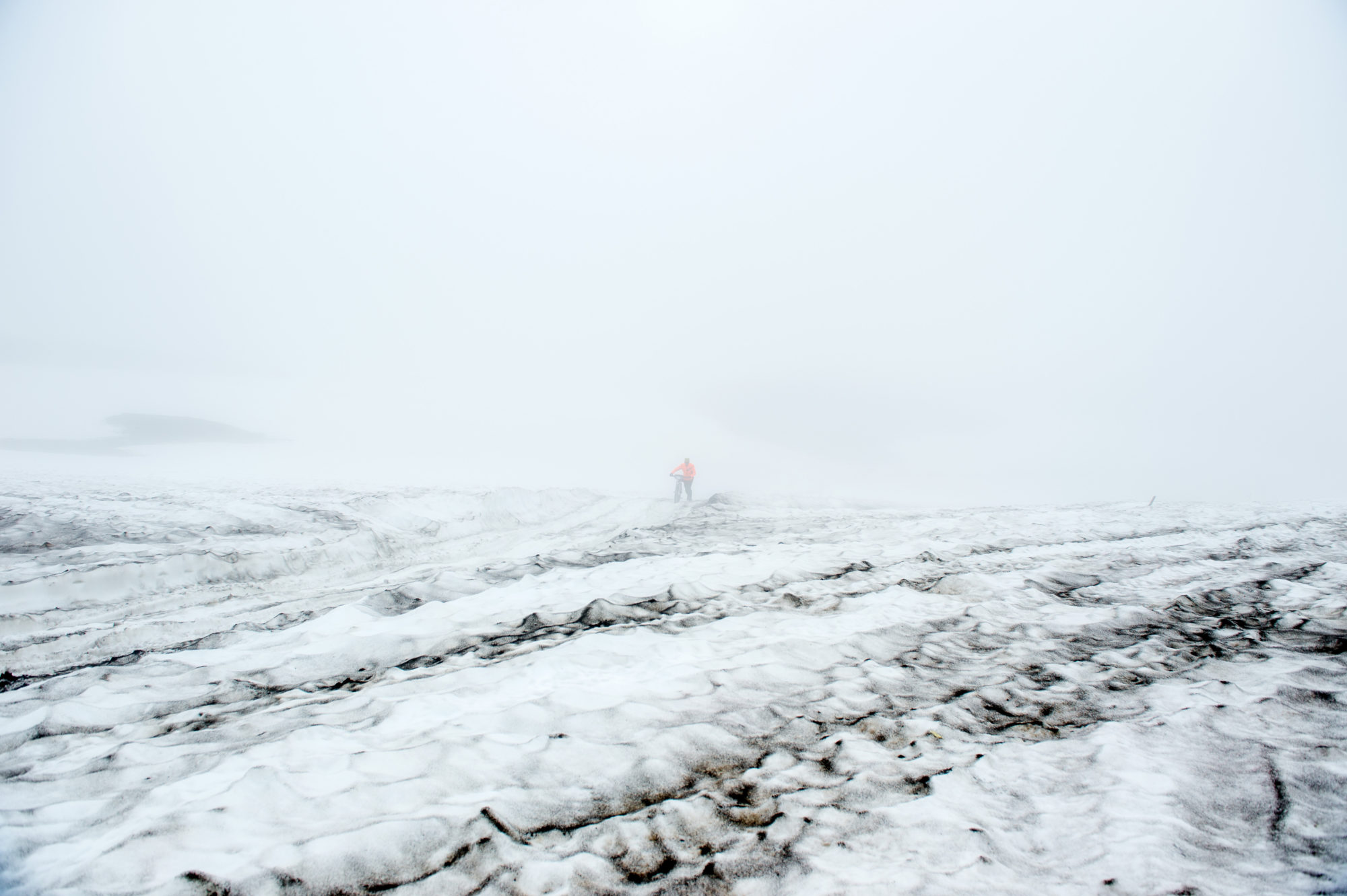 Foto di aldo mazzocchi è costretto a spingere la bicicletta sulla troppa neve che ricopre la strada che porta al campo base verso il vulcano gorely