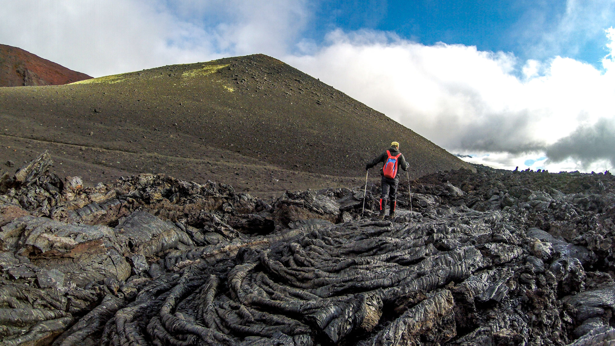 Foto di aldo mazzocchi cammina su una distesa di lava per risalire il vulcano tolbachick