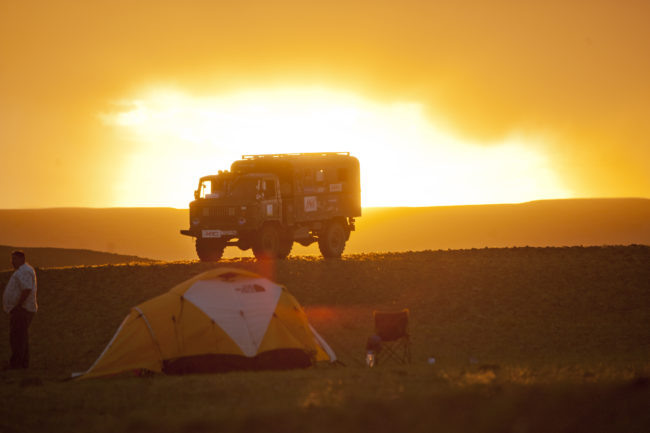 Camion al tramonto in una pianura della Mongolia