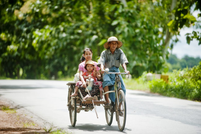 Famiglia viaggia in bicicletta su una strada in Myanmar