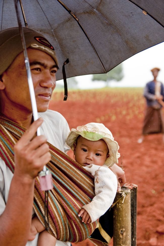 Padre e figlia sotto la pioggia in campagna in Myanmar