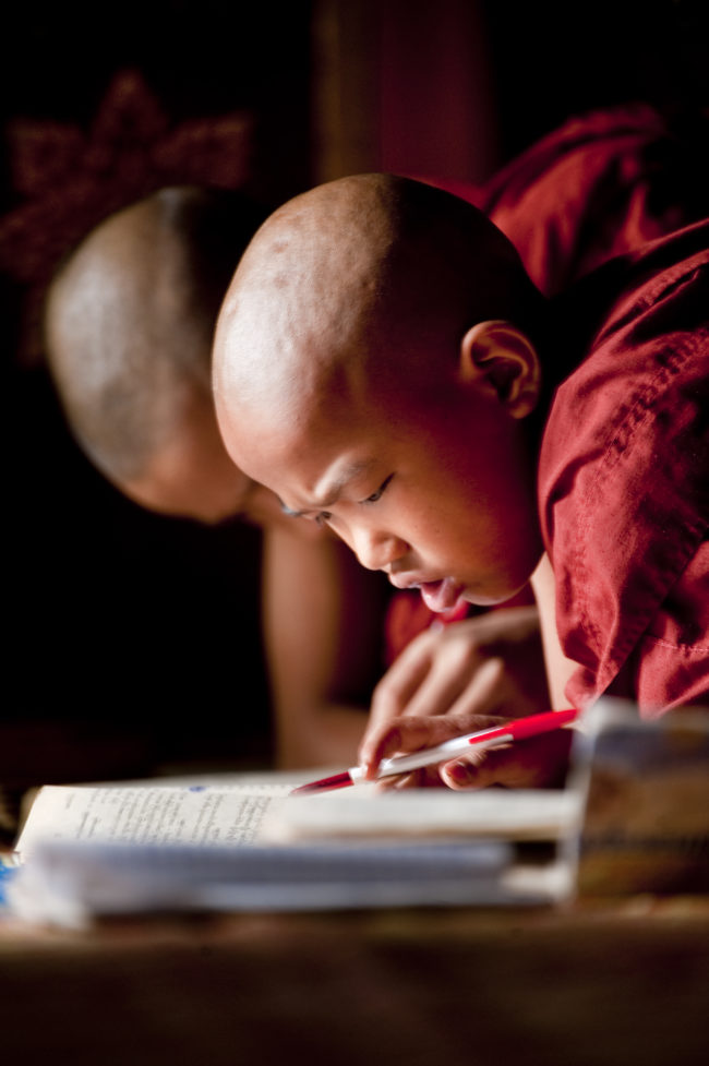 Giovani monaci buddisti che studiano in un tempio in Myanmar