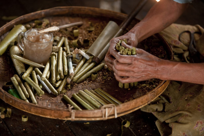 Donna al lavoro che preapra tipici sigari del Myanmar