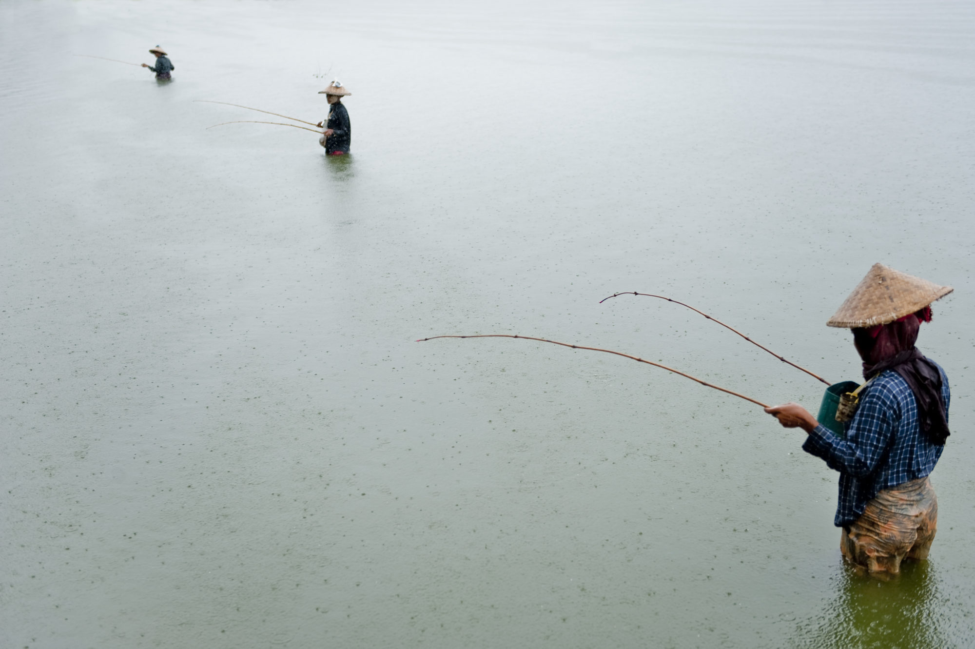 Foto di Pescatori al lavoro sul lago Inle in Birmania sotto la pioggia
