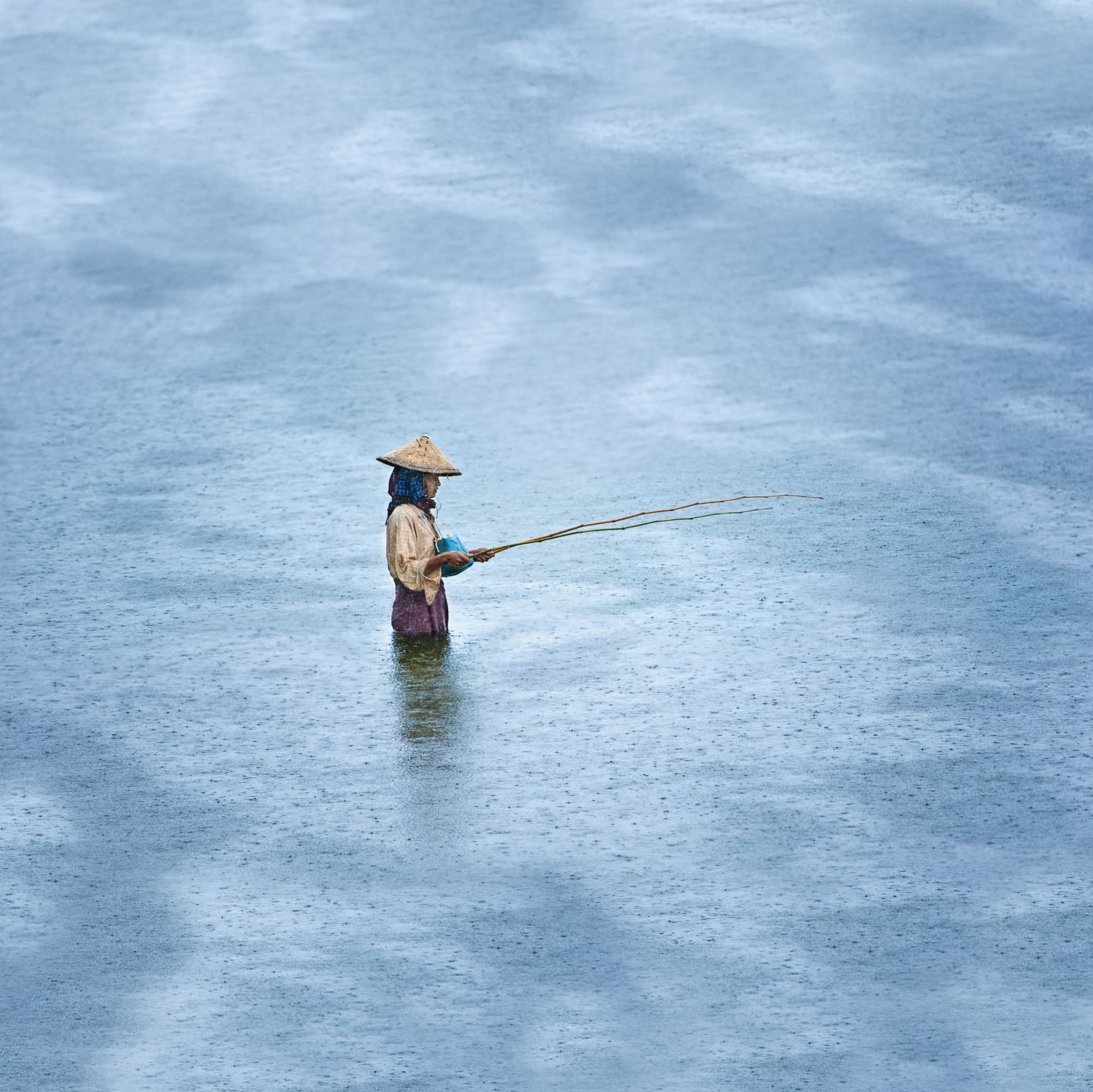 Foto di Pescatore al lavoro sul lago Inle in Myanmar sotto la pioggia