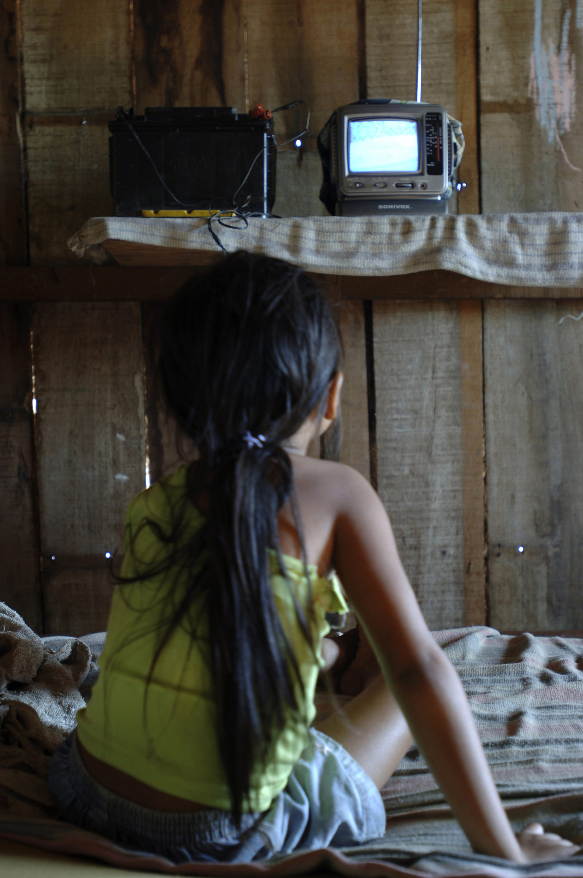 Foto di bambina guarda la tv alimentata con una batteria da auto