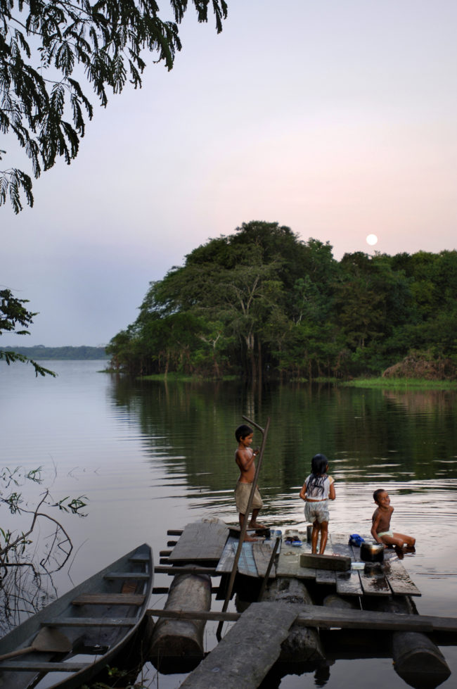 bambini giocano nell'acqua di un fiume amazzonico