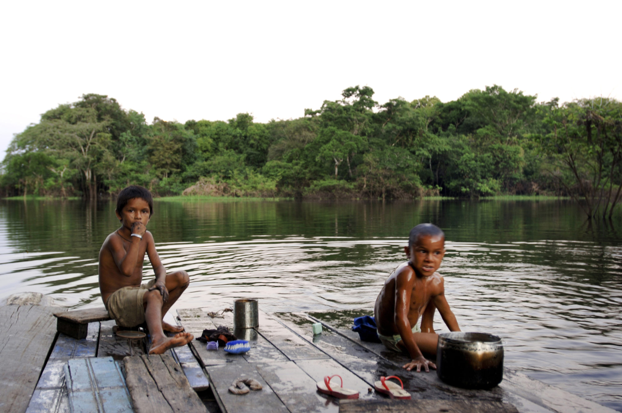 Foto di bambini giocano nell’acqua di un fiume amazzonico