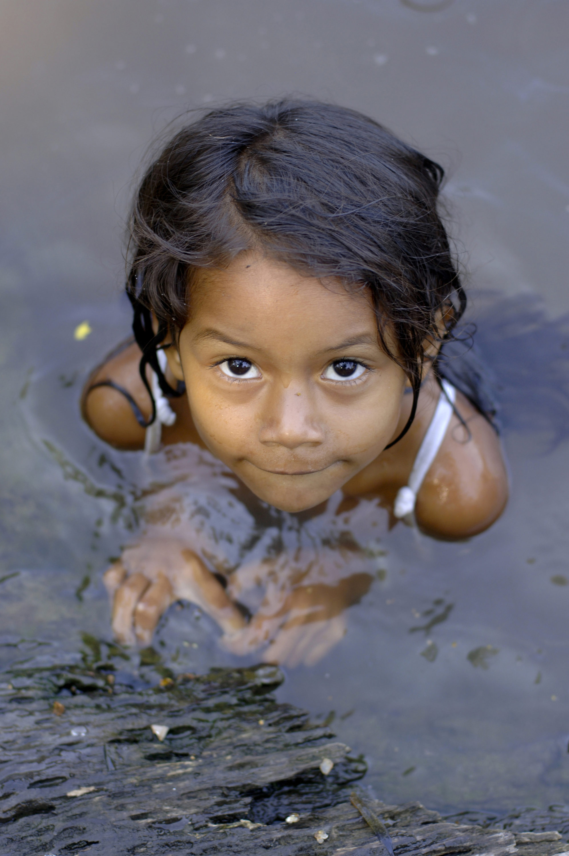 Foto di bambina gioca nell’acqua di un fiume amazzonico