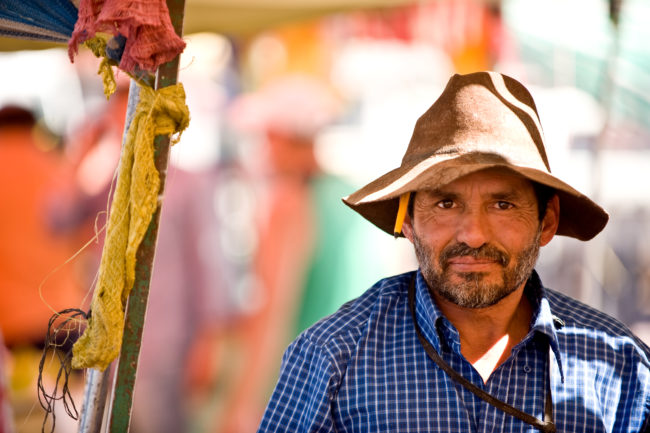 uomo con un cappello particolare in un mercato di san pedro de atacama