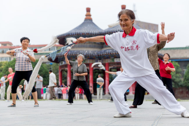 Un gruppo di persone pratica il tai chi in un parco di Tianshui