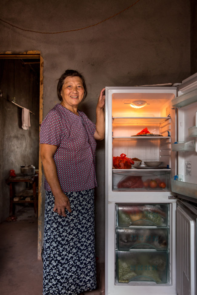 Una donna mostra orgogliosa l'interno del suo frigorifero