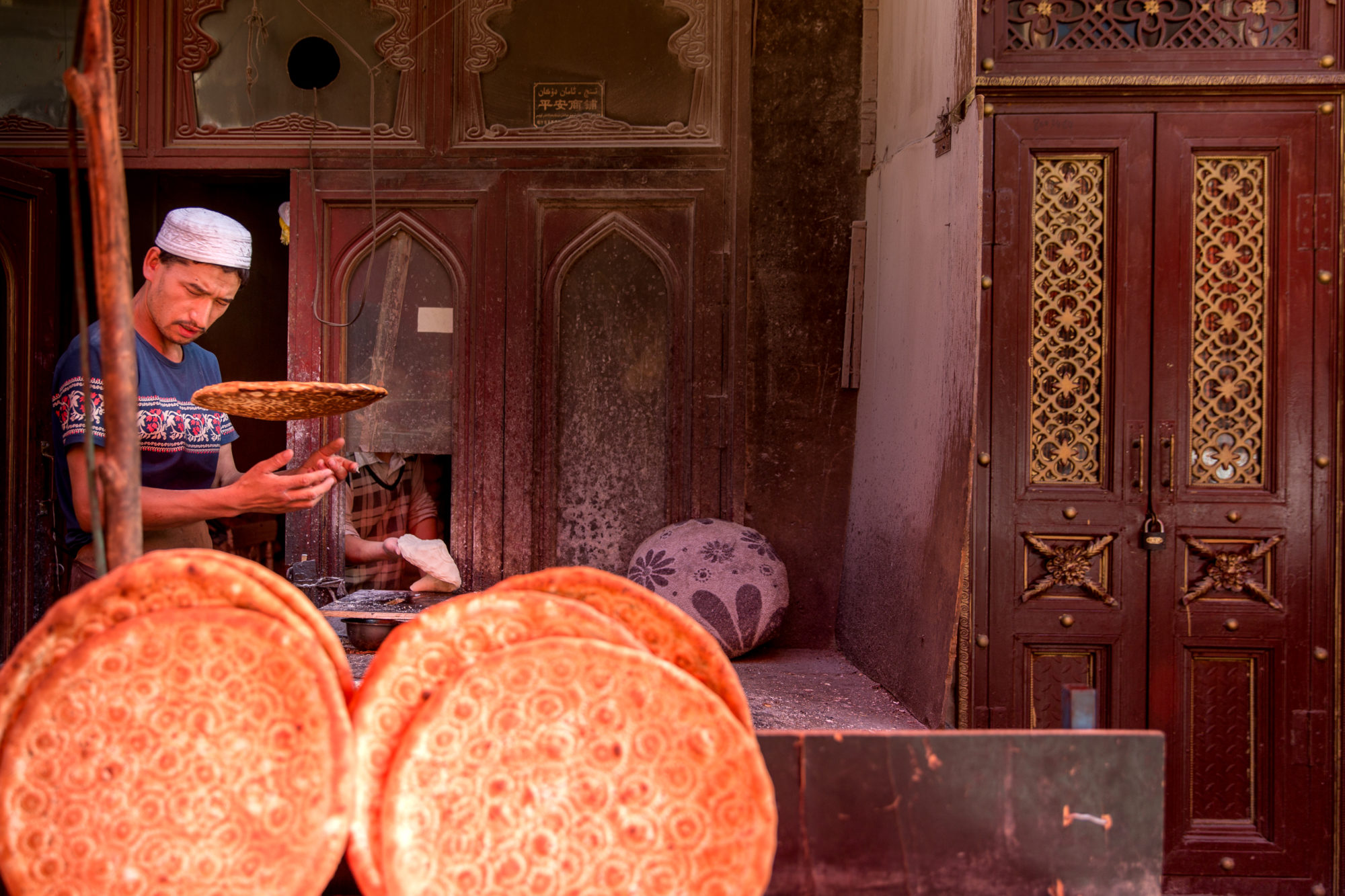 Foto di Kashgar. Un uomo prepara un particolare pane chiamato Nang