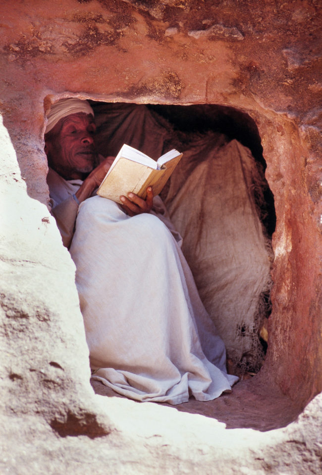 Uomo che legge in una cripta