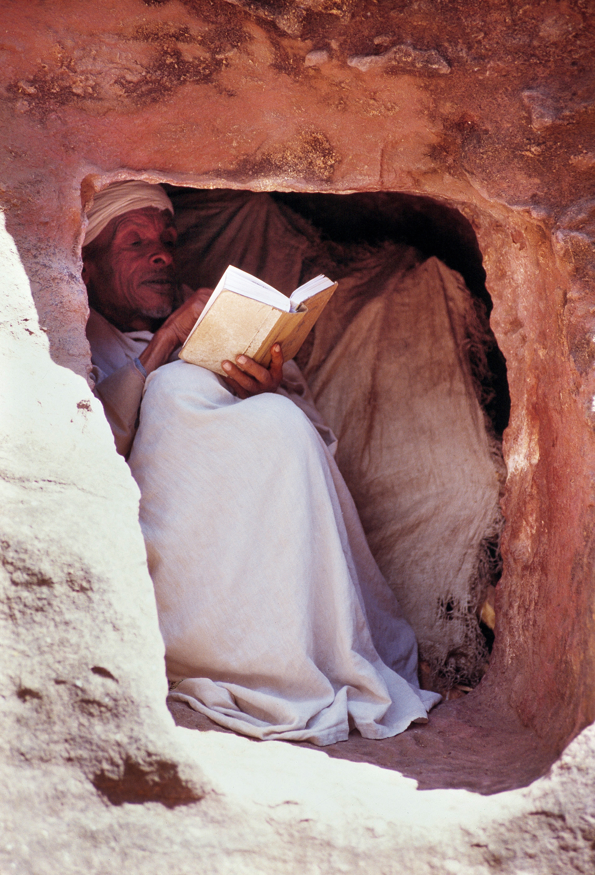 Foto di Uomo che legge in una cripta