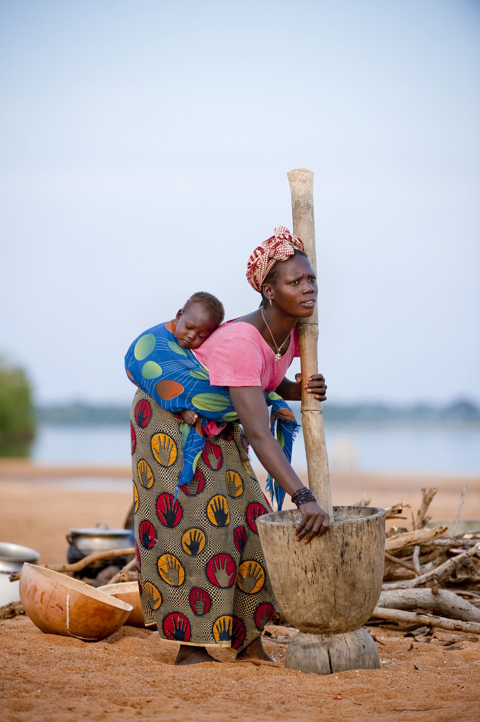 Foto di Donna lavora con il mortaio sul fiume Niger