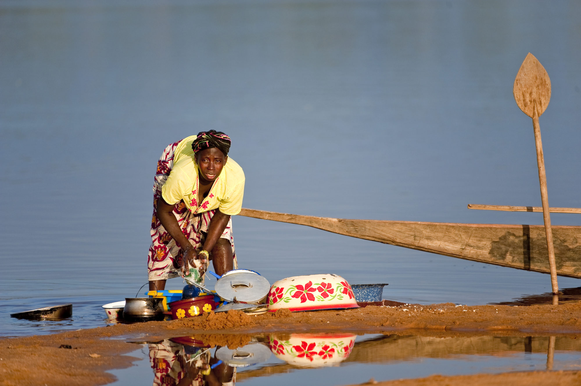 Foto di Donna lava le stoviglie nel fiume Niger