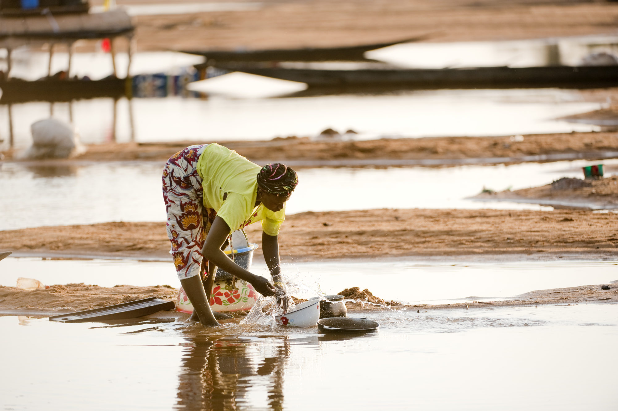 Foto di Donna lava le stoviglie nel fiume Niger