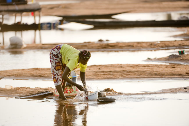 Donna lava le stoviglie nel fiume Niger