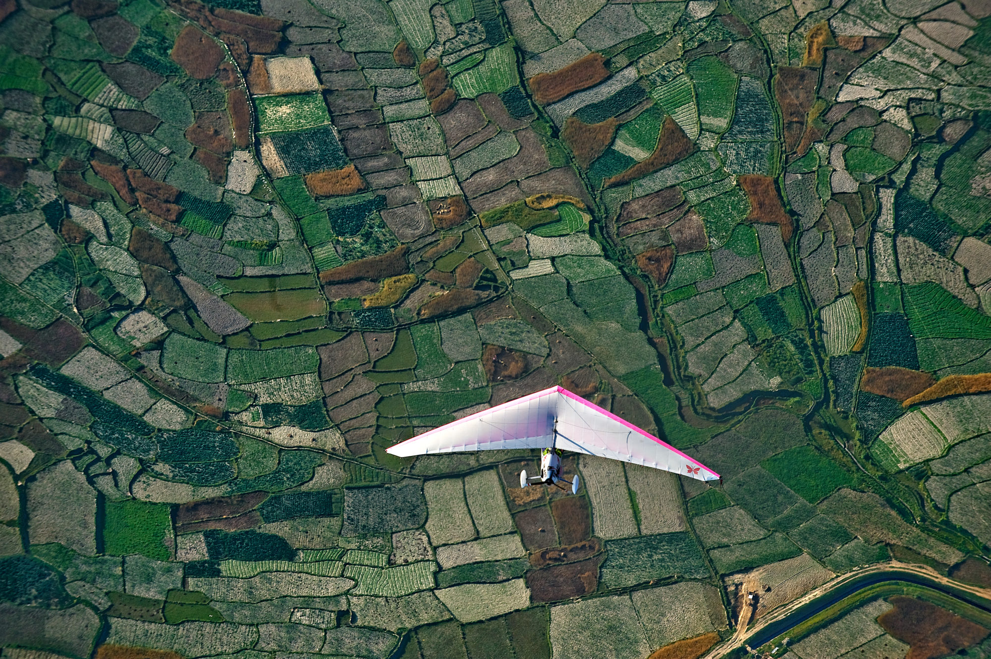 Foto di Deltaplano che vola sopra terreni agricoli