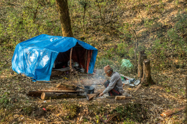 Boscaiolo che cucina davanti alla sua tenda
